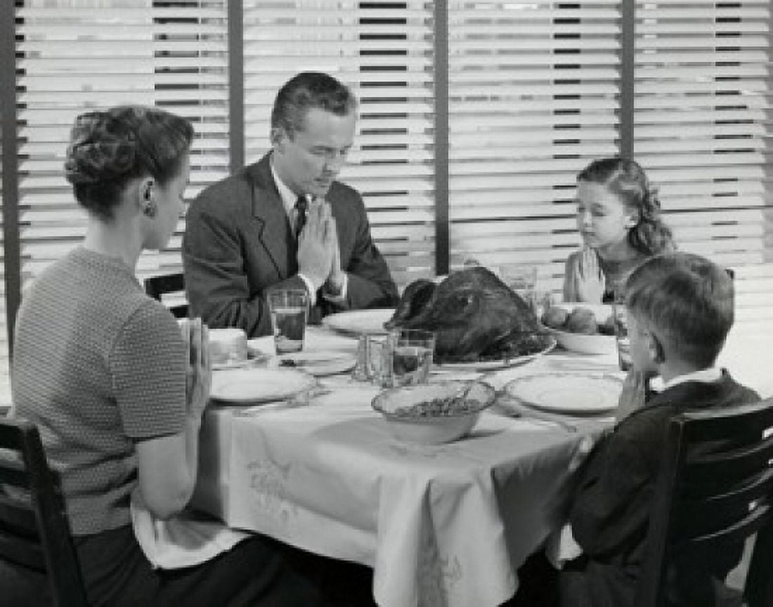 Mature couple with their two children praying at a dining table on Thanksgiving Day Canvas Art - (24 x 36)