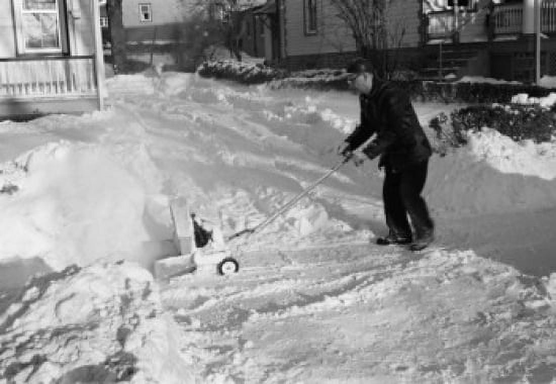 Mature man clearing snow from approach to suburban home Canvas Art - (18 x 24)