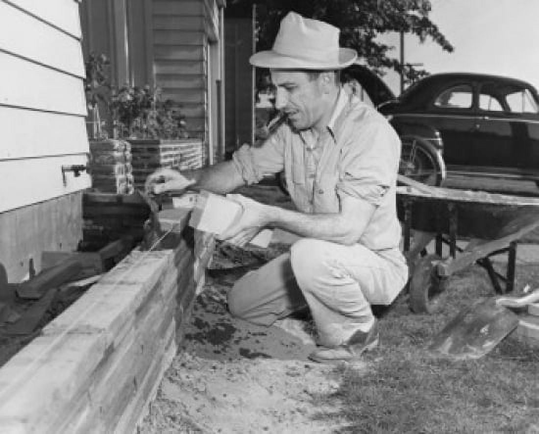 Mature man constructing a wall outside his house Canvas Art - (24 x 36)