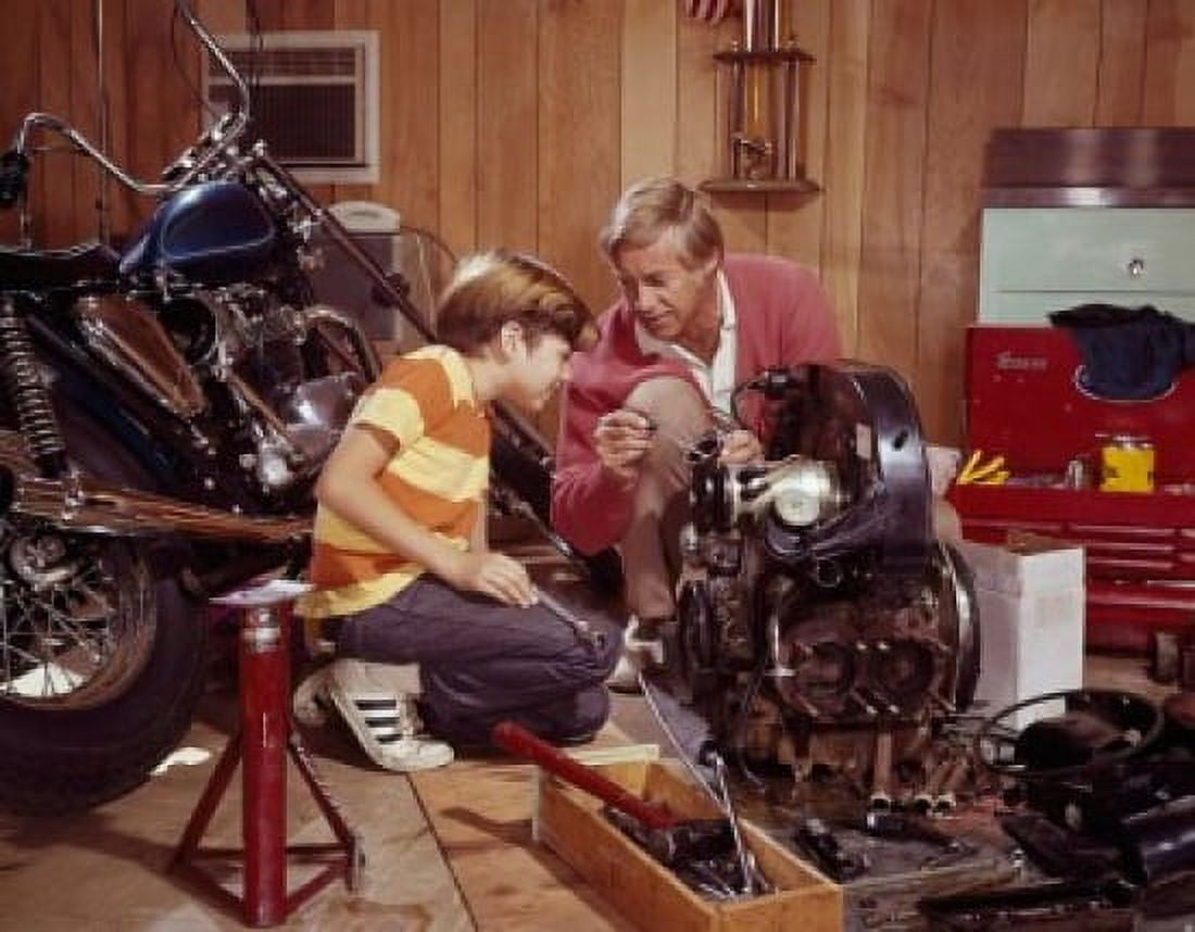 Mature man explaining an automobile engine to his son in a workshop Canvas Art - (18 x 24)