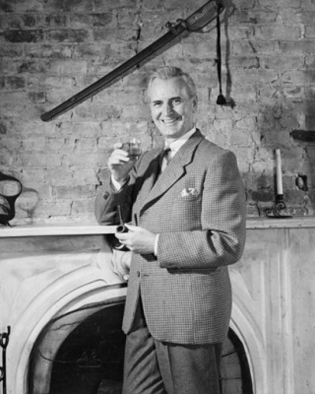 Mature man holding a glass of wine and standing in front of a fireplace Canvas Art - (18 x 24)