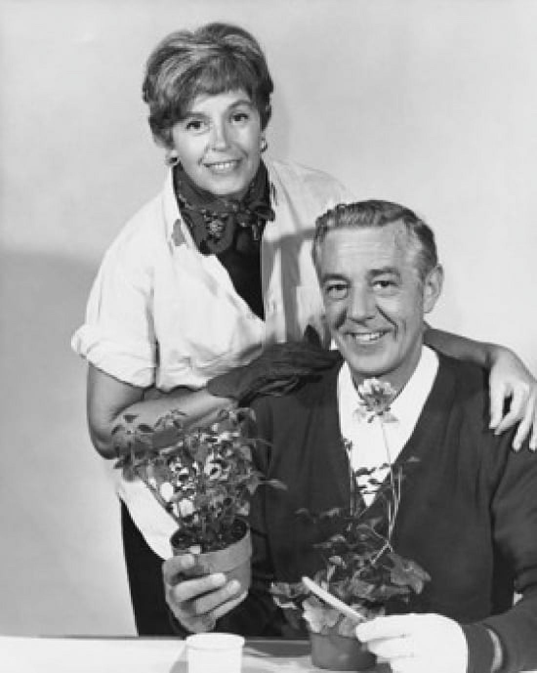 Mature man holding a potted plant with a mature woman standing behind him Canvas Art - (24 x 36)