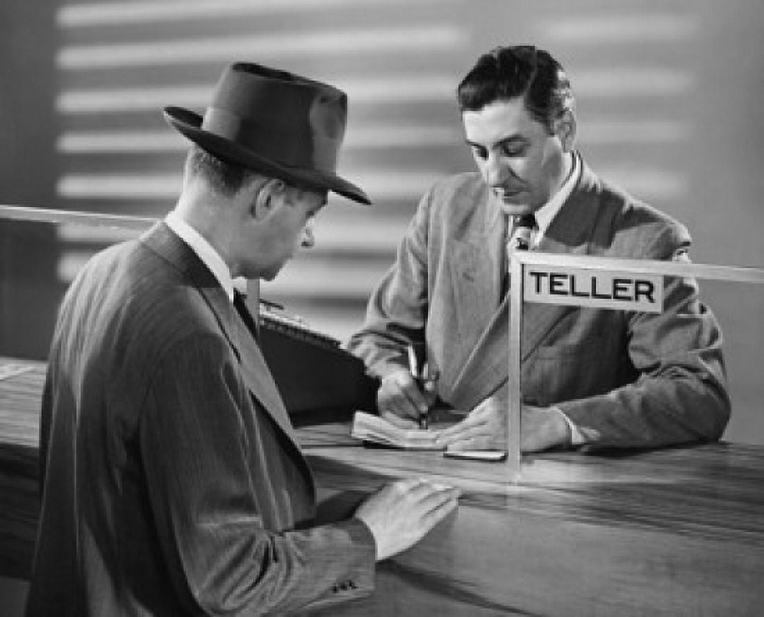 Mature man standing in front of a bank teller in a bank Canvas Art - (24 x 36)