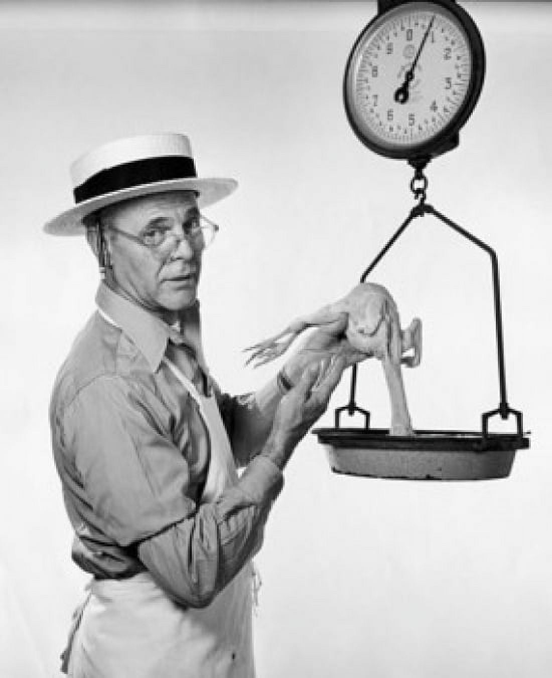 Mature man weighing a dead chicken Canvas Art - (18 x 24)