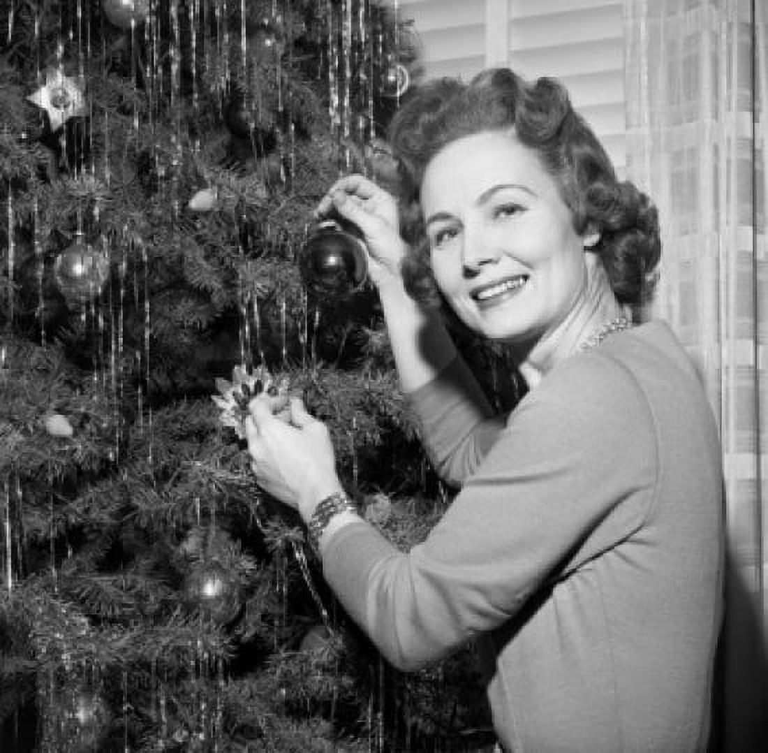 Mature woman decorating Christmas tree Canvas Art - (24 x 36)
