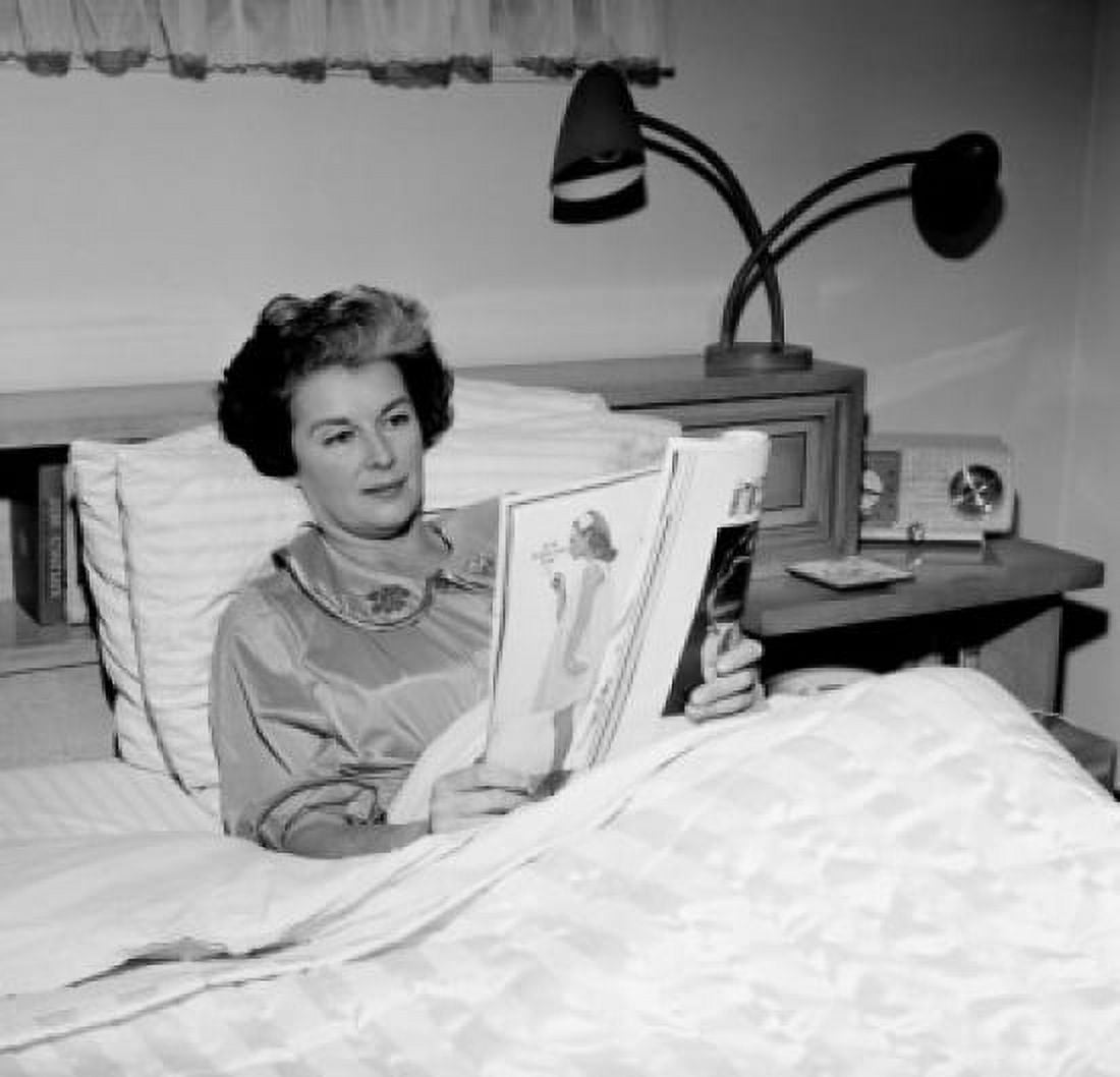 Mature woman sitting in bed reading magazine Canvas Art - (24 x 36)
