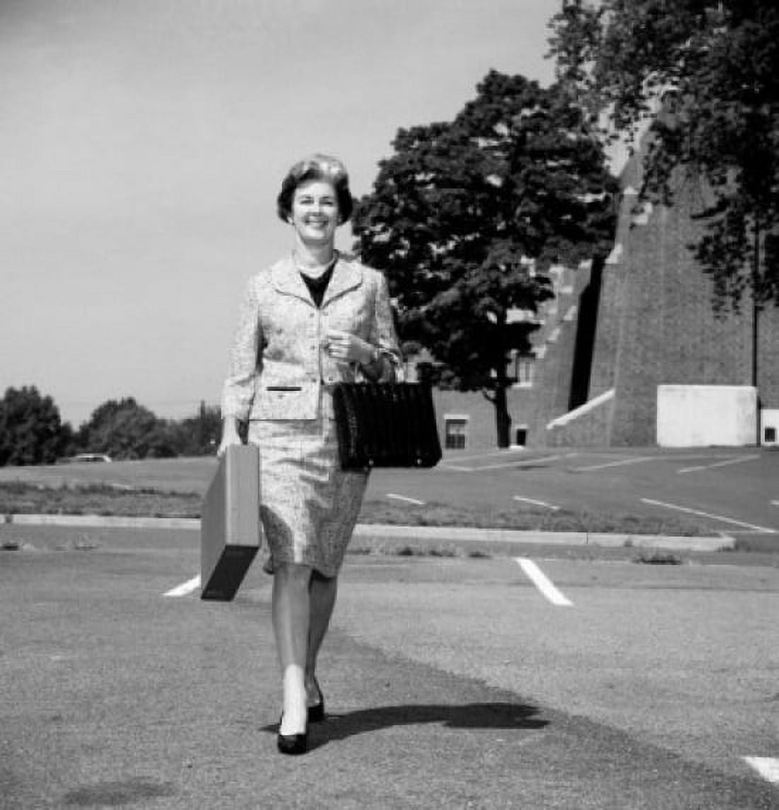 Mature woman walking on parking lot and carrying suitcases Canvas Art - (24 x 36)