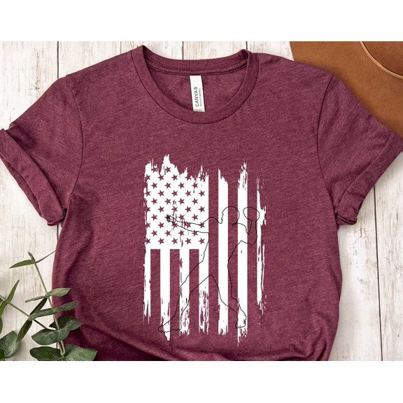May include A maroon tshirt with a white graphic of a baseball player silhouetted against