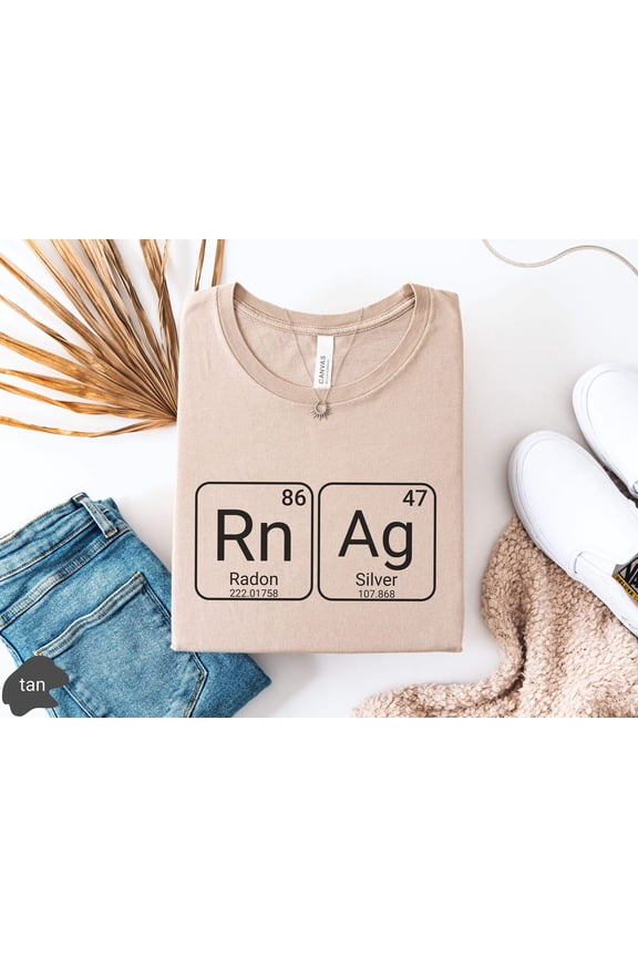 May include Tan tshirt with a graphic of the periodic table elements Radon and Silver