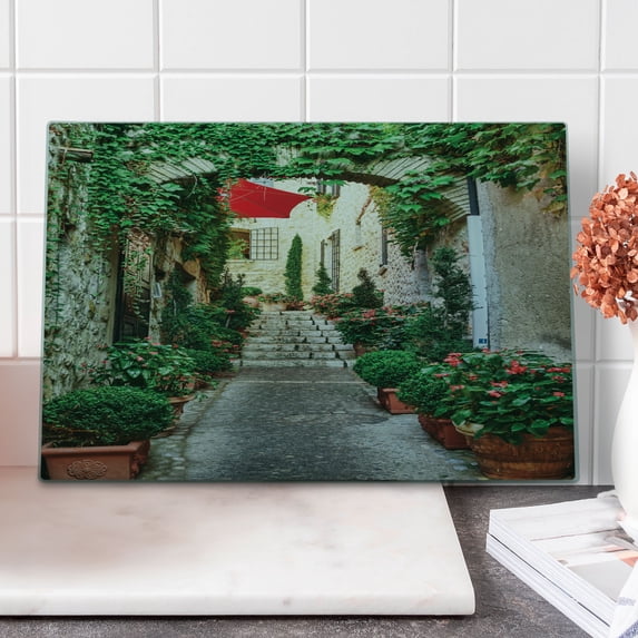 Mediterranean Cutting Board, Narrow Street with Flowers Rural Wine Town in Southern France Provinces Photo, Decorative Tempered Glass Cutting and Serving Board, Large Size, Grey Green, by Ambesonne