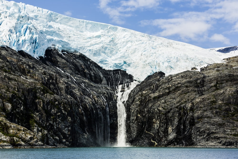 Meltwater from the Northland Glacier along Blackstone Bay creates a waterfall near Whittier in Southcentral Alaska Canvas Art - Ray Bulson Design Pics (20 x 13)