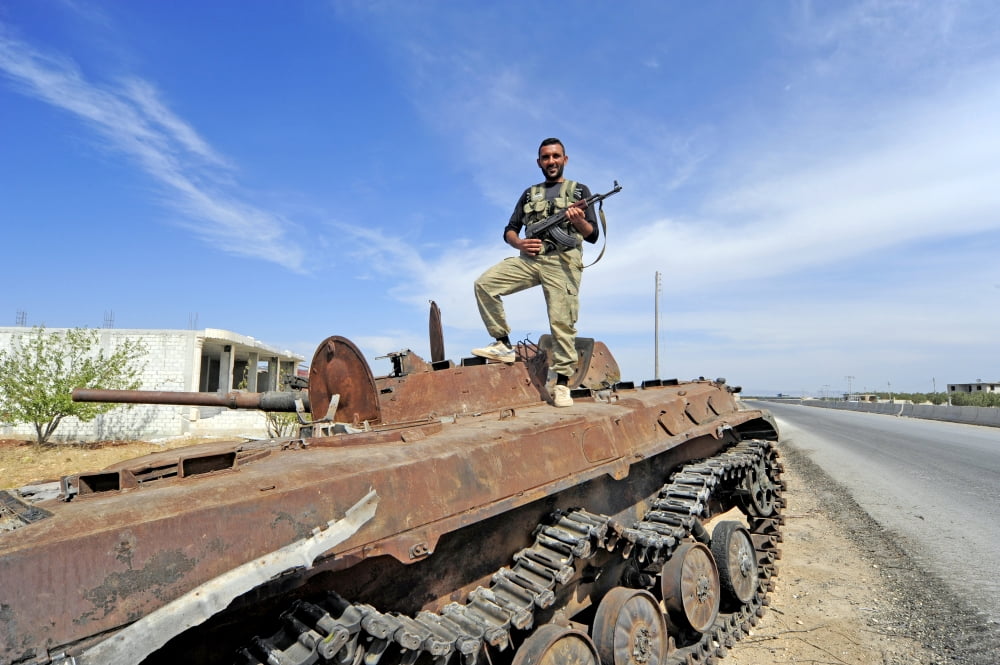 Member of the Free Syrian Army stands on top of a demolished tank Canvas Art - Andrew ChittockStocktrek Images (35 x 23)