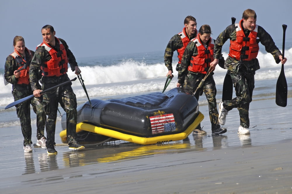 Members of the US National Swim Team carry their boat ashore after completing a surf passage Canvas Art - Stocktrek Images (35 x 23)