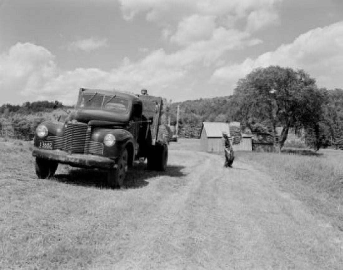 Men picking straw bale from field Canvas Art - (24 x 36)