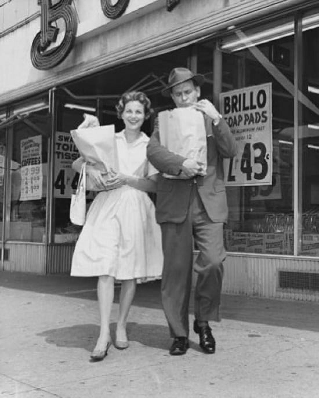 Mid adult couple carrying shopping bags in front of a store Canvas Art - (24 x 36)