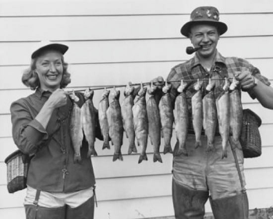 Mid adult couple holding rod with rainbow trout hanging on it Canvas Art - (18 x 24)