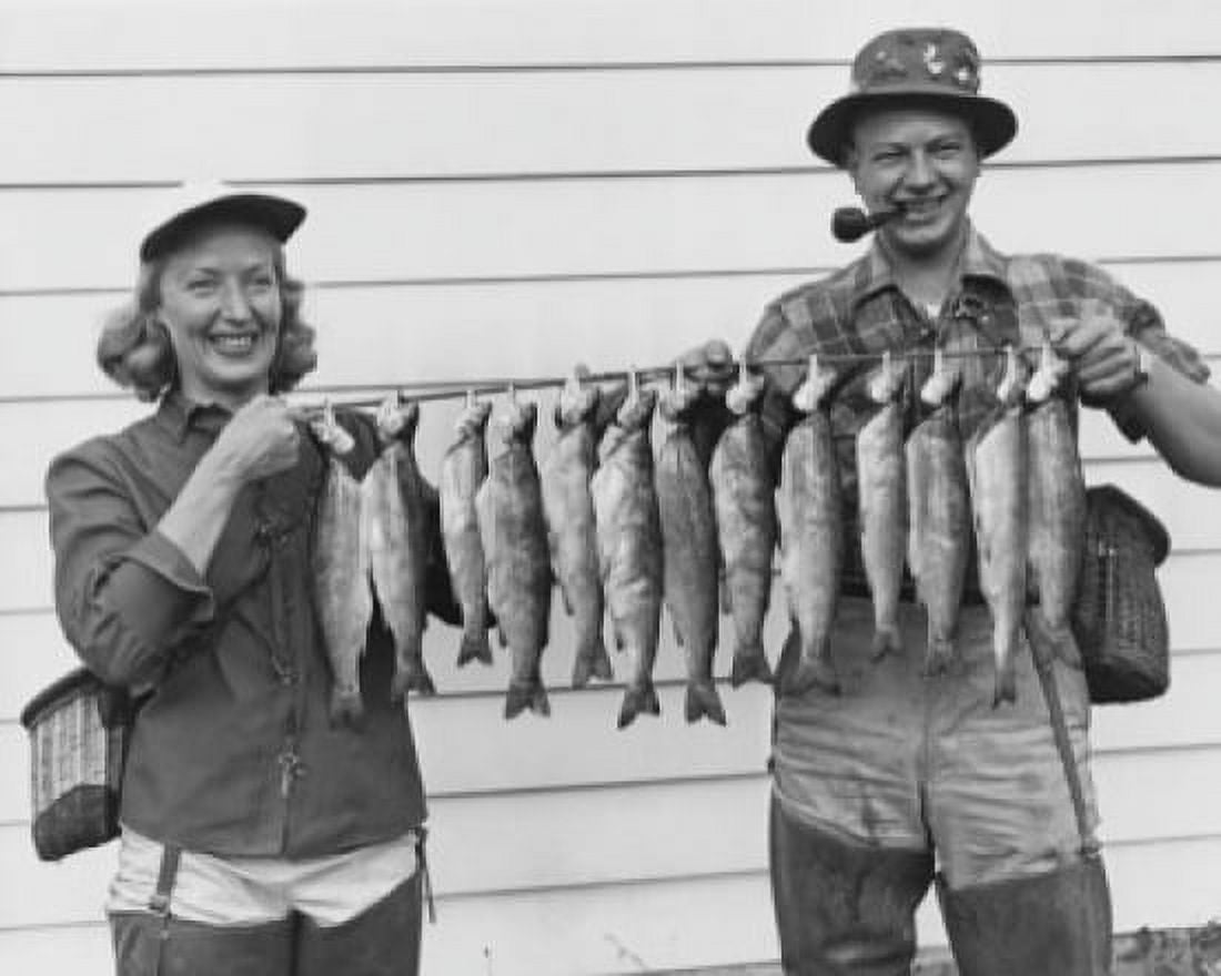 Mid adult couple holding rod with rainbow trout hanging on it Canvas Art - (24 x 36)
