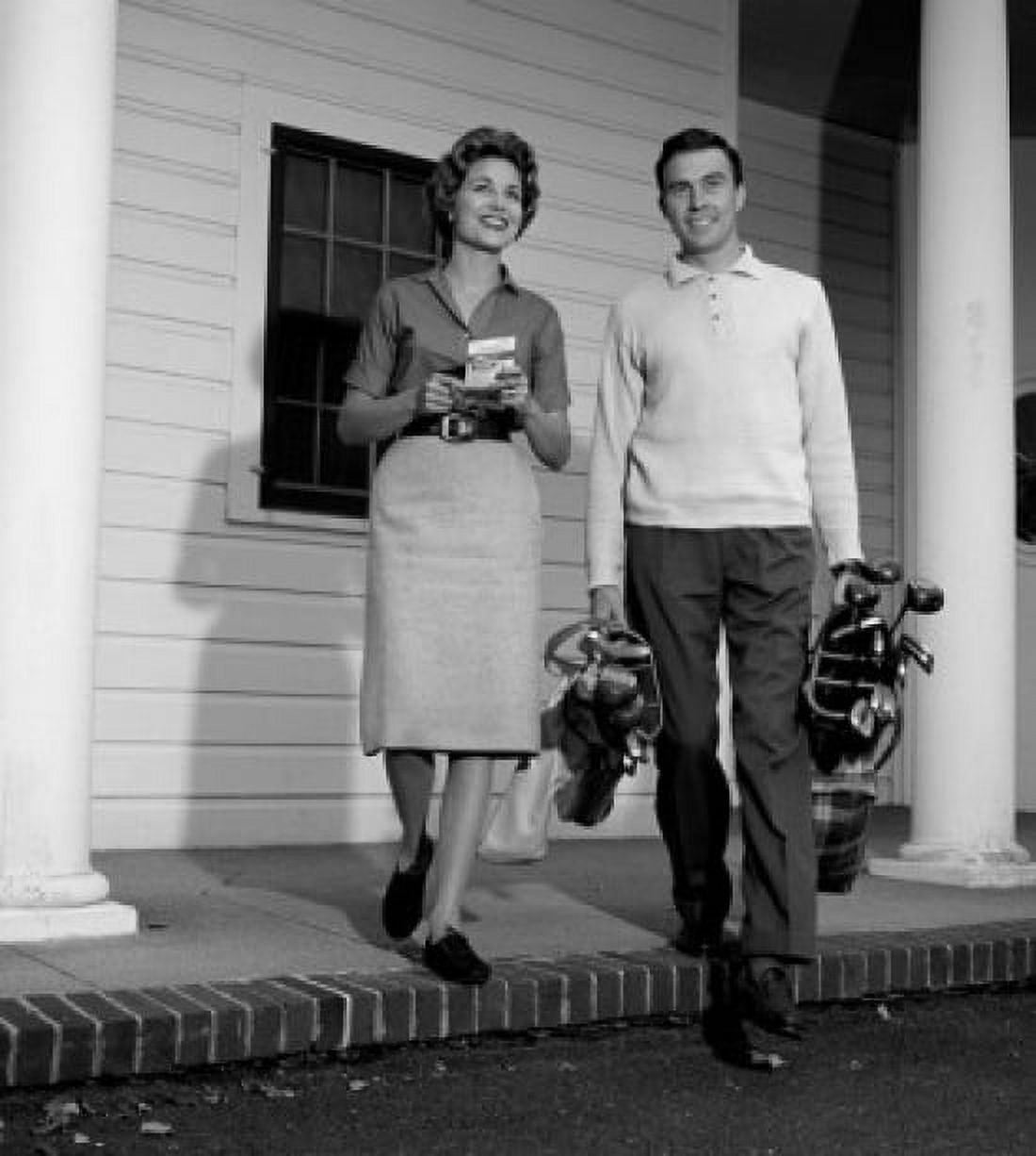 Mid adult couple leaving for golf session Canvas Art - (18 x 24)