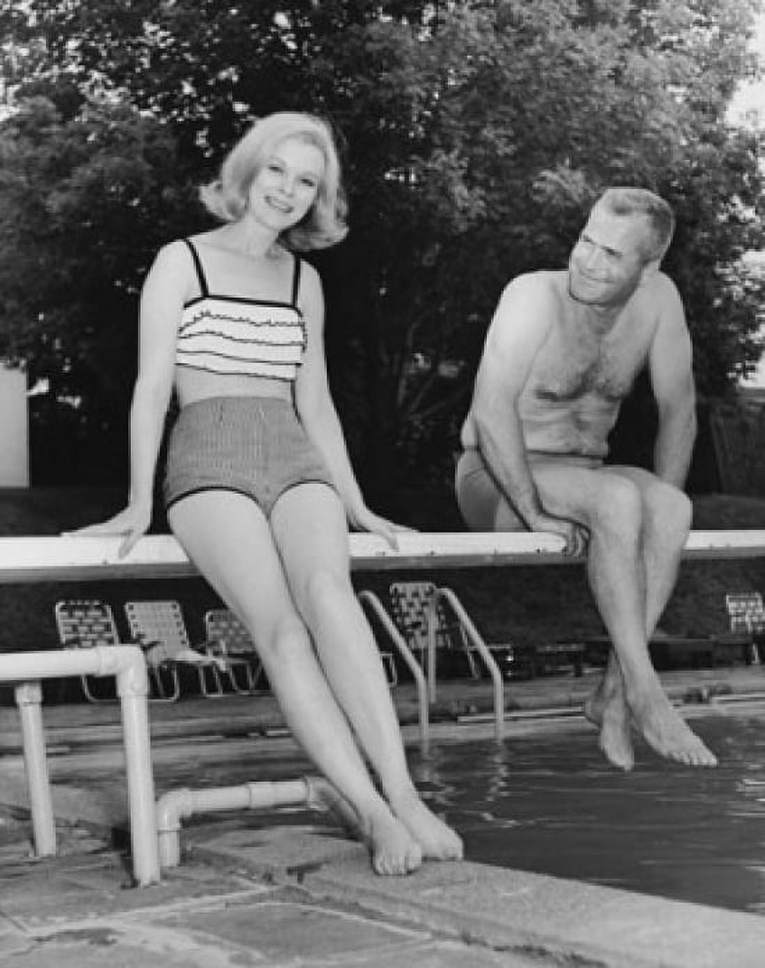 Mid adult couple sitting on a diving board at a swimming pool Canvas Art - (18 x 24)