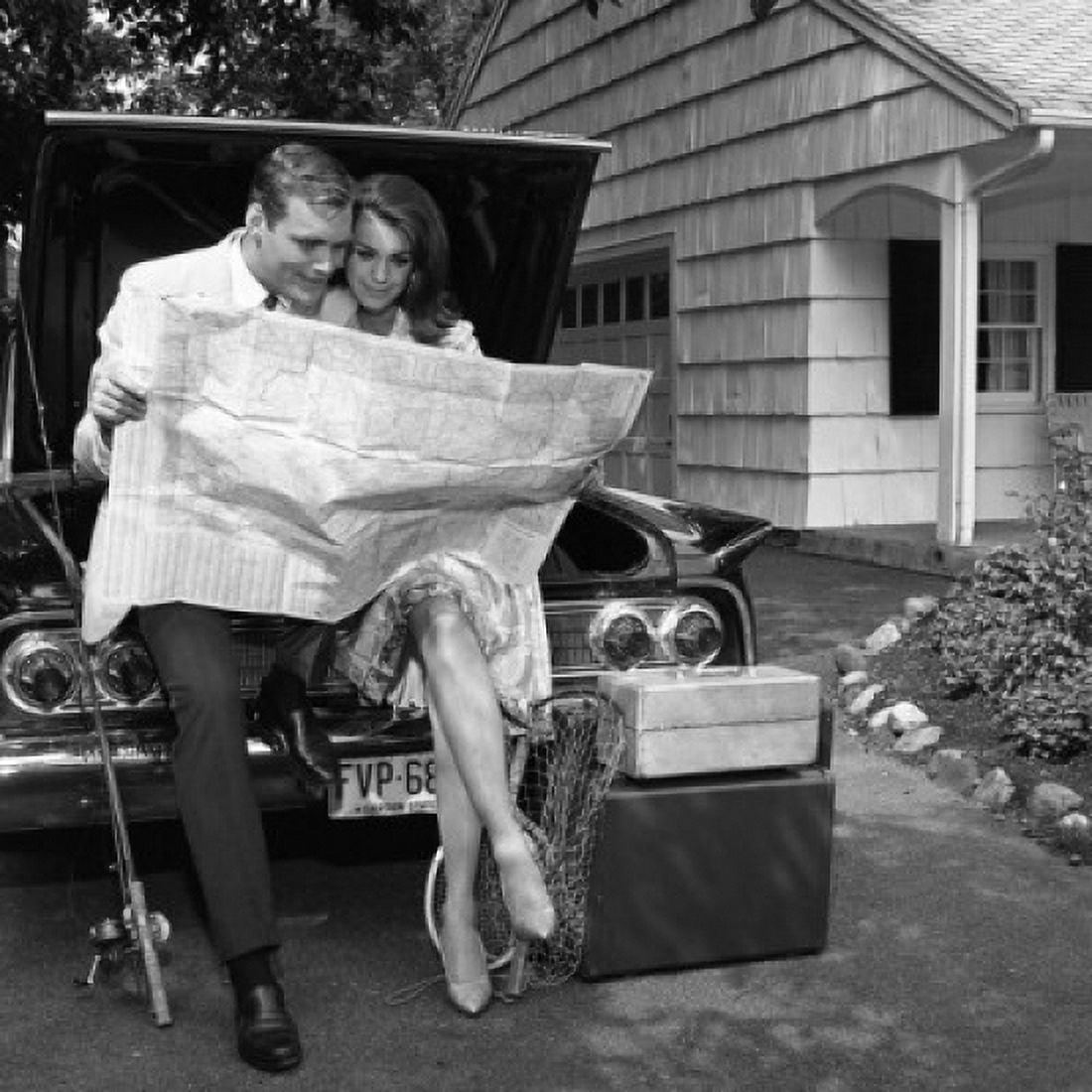 Mid adult couple sitting on car and reading map Canvas Art - (24 x 36)