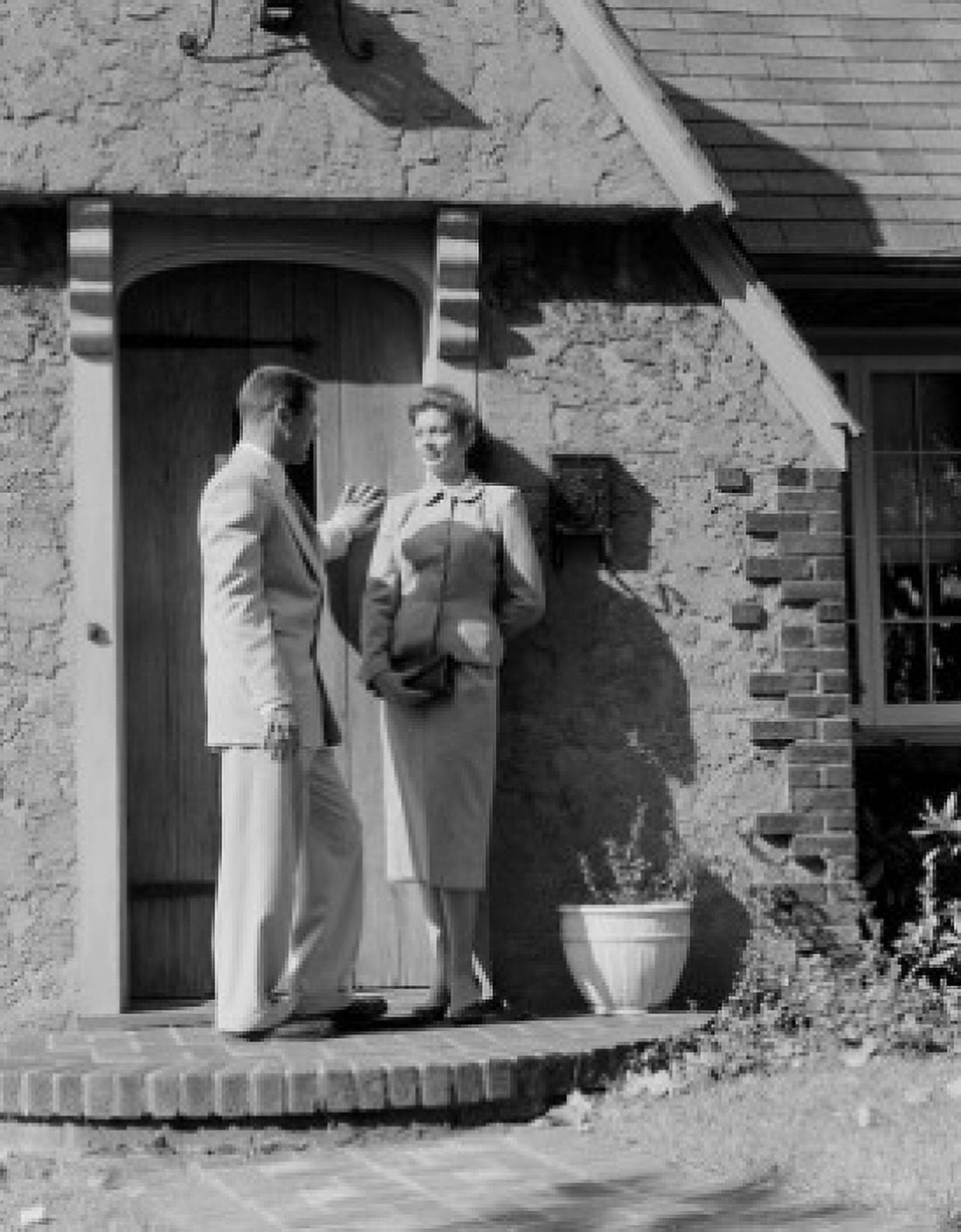 Mid adult couple standing and talking in front of house Canvas Art - (24 x 36)
