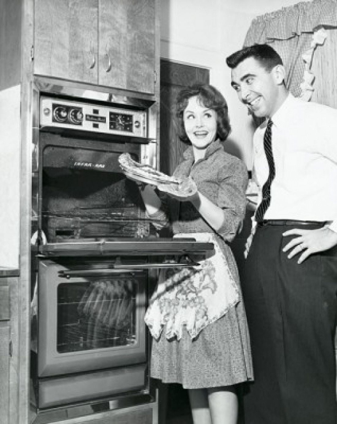 Mid adult couple standing near an oven and smiling Canvas Art -  (18 x 24)