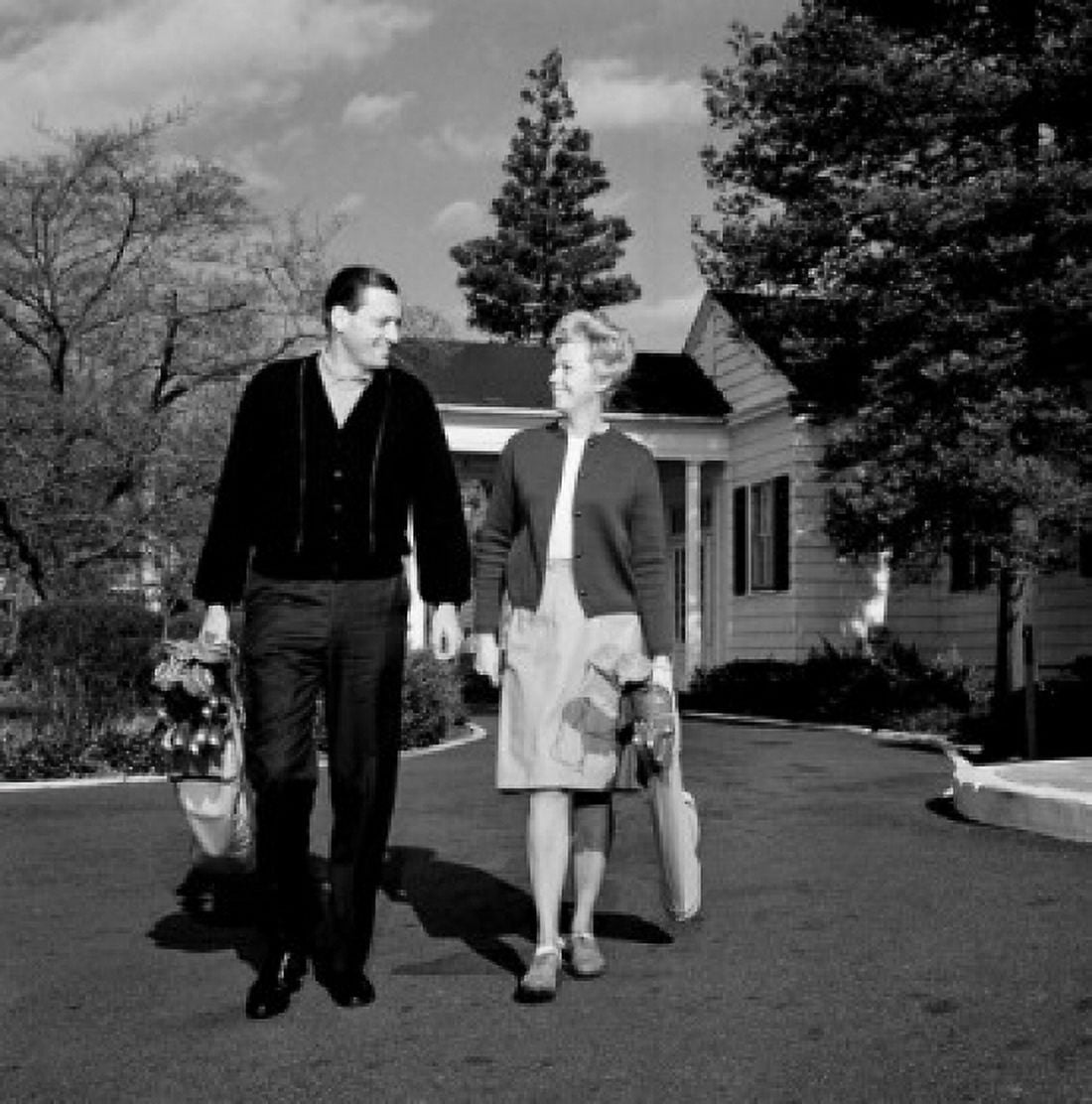 Mid adult couple walking side by side carrying golf clubs Canvas Art - (18 x 24)
