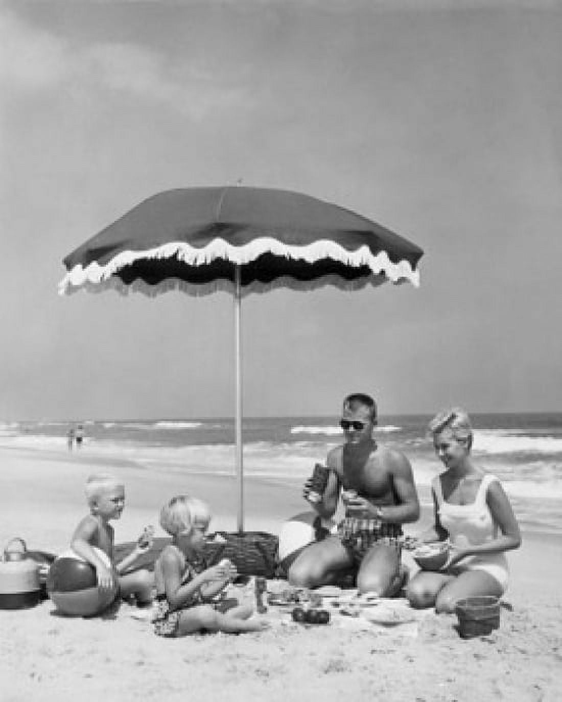 Mid adult couple with two children at picnic on beach Canvas Art - (18 x 24)