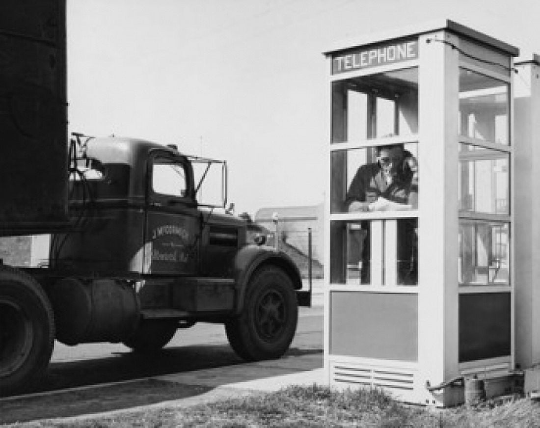 Mid adult man a talking on the phone in a telephone booth Canvas Art - (24 x 36)