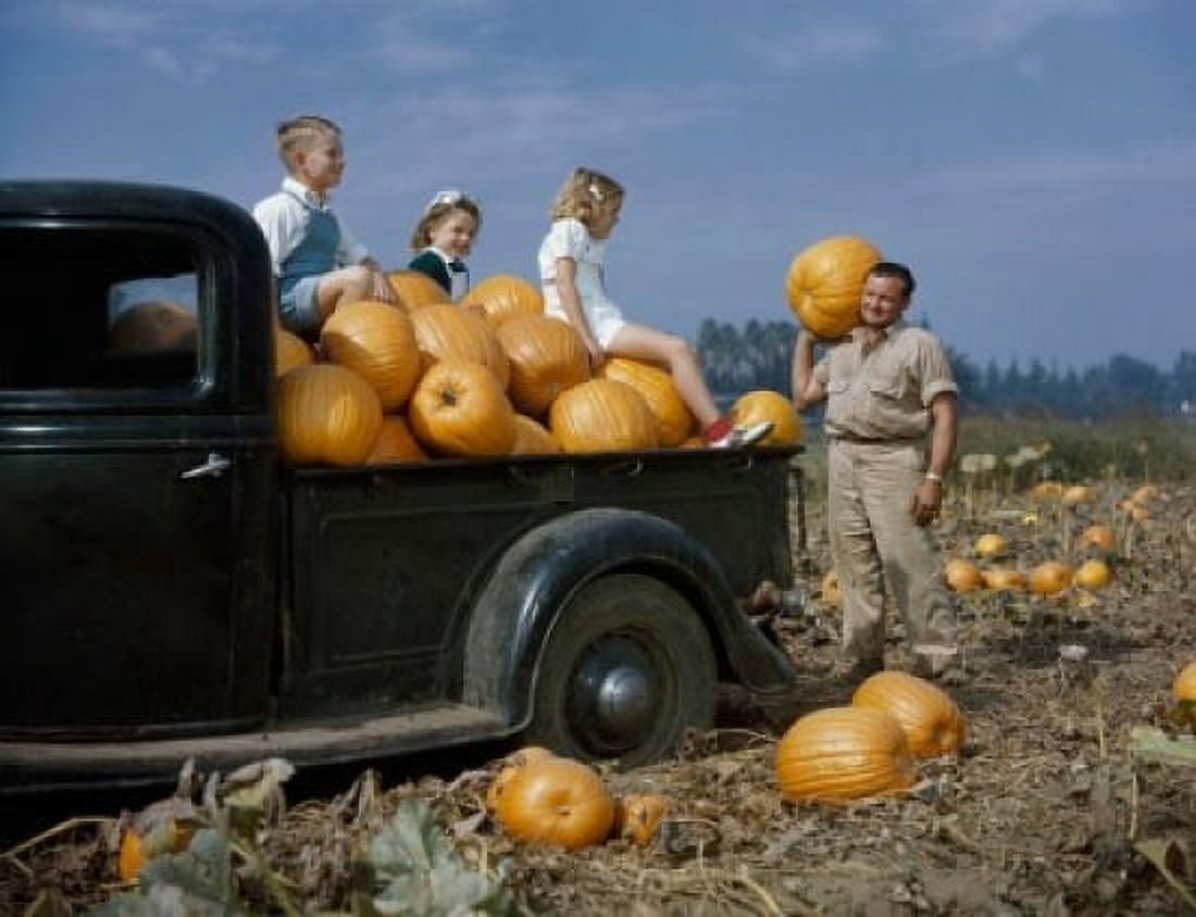 Mid adult man carrying a pumpkin on his shoulder with his three children sitting on pumpkins in a pick-up truck Canvas Art - (18 x 24)