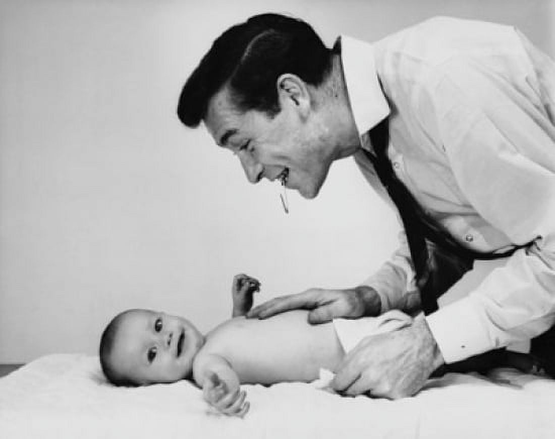 Mid adult man changing the diaper of his baby Canvas Art - (18 x 24)