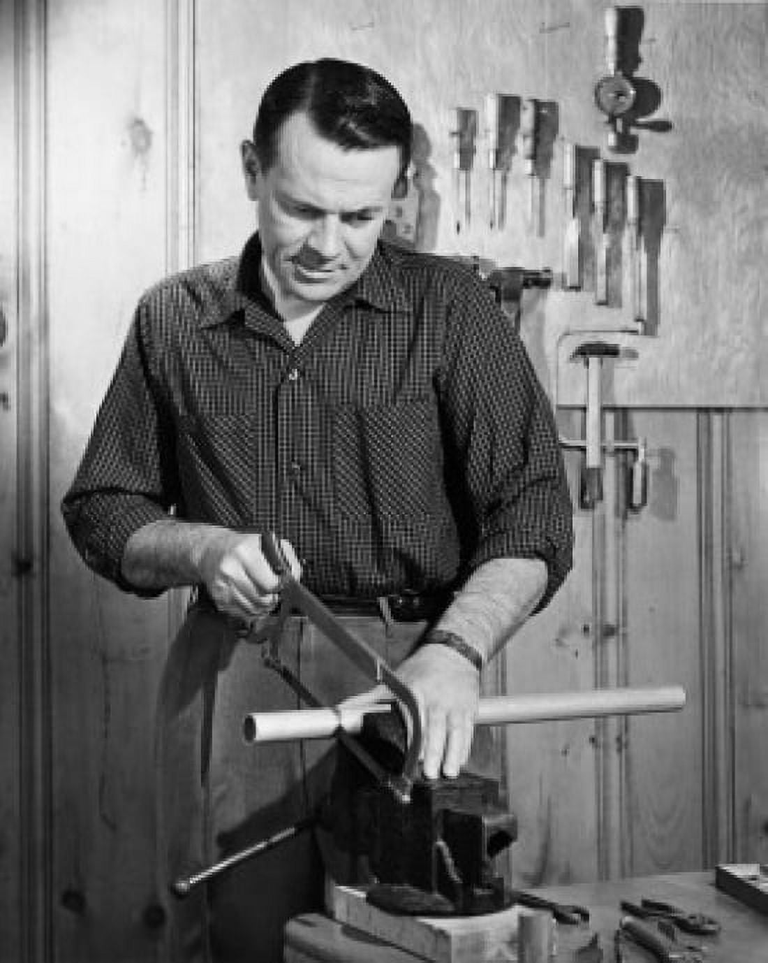 Mid adult man cutting a pipe with a saw in a workshop Canvas Art - (18 x 24)