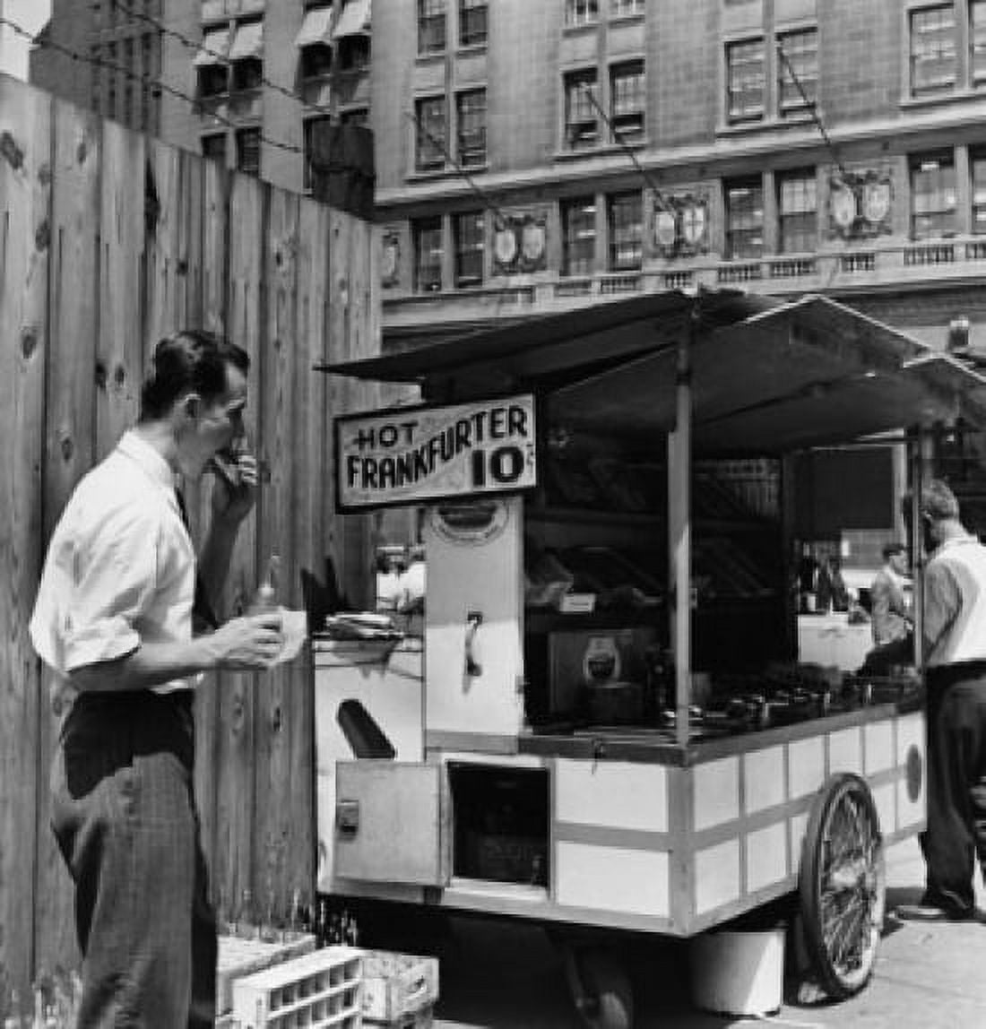 Mid adult man eating food near a hot dog stand New York City New York USA Canvas Art -  (18 x 24)