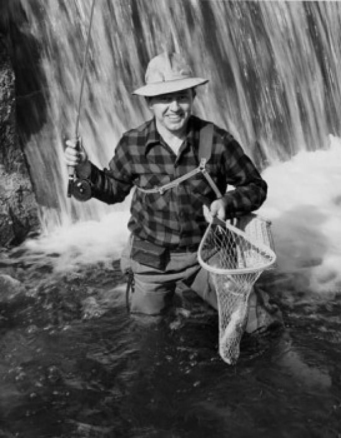 Mid adult man holding dead fish in fishing net and smiling Canvas Art - (24 x 36)