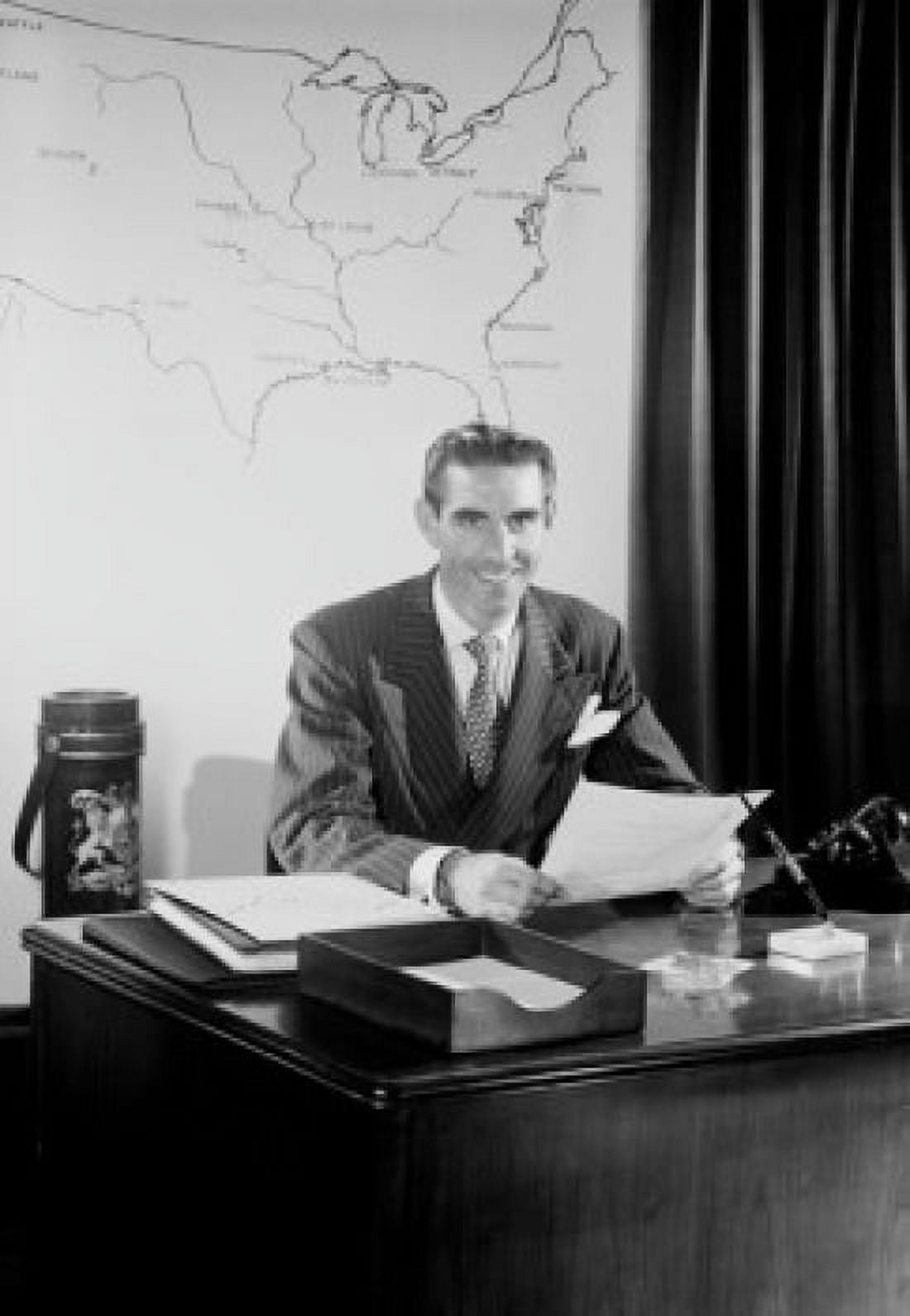 Mid adult man sitting at desk in office Canvas Art - (24 x 36)