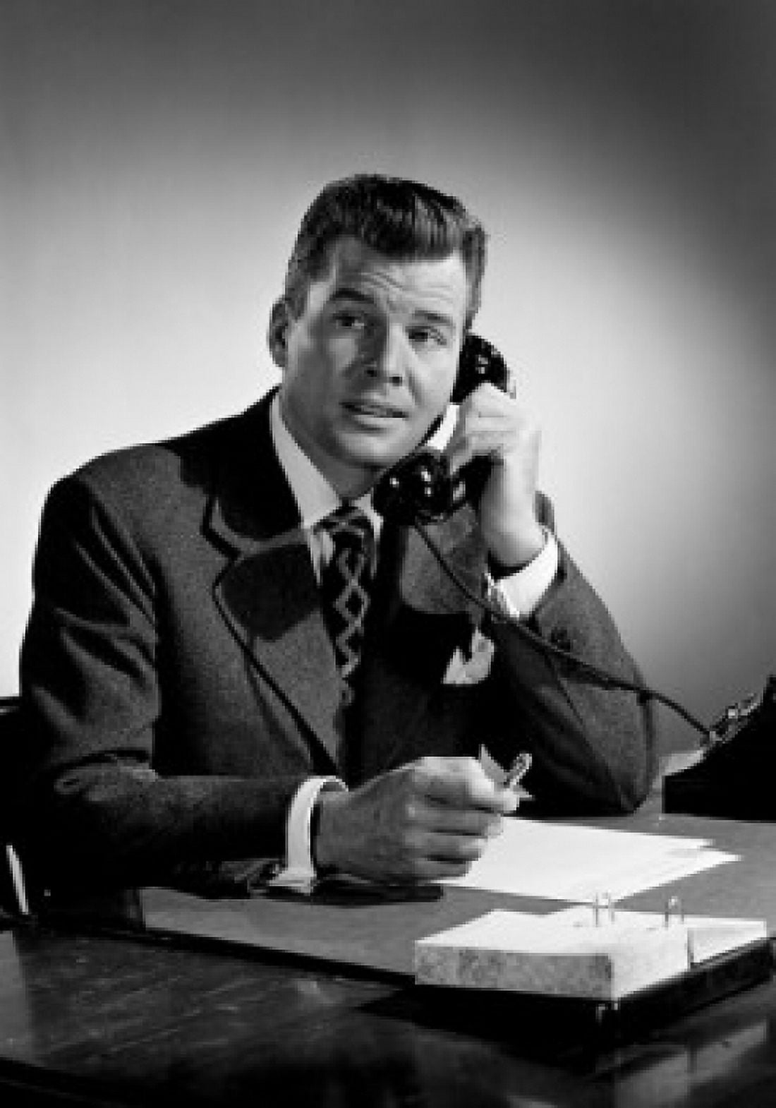 Mid adult man sitting at desk talking on phone Canvas Art - (18 x 24)