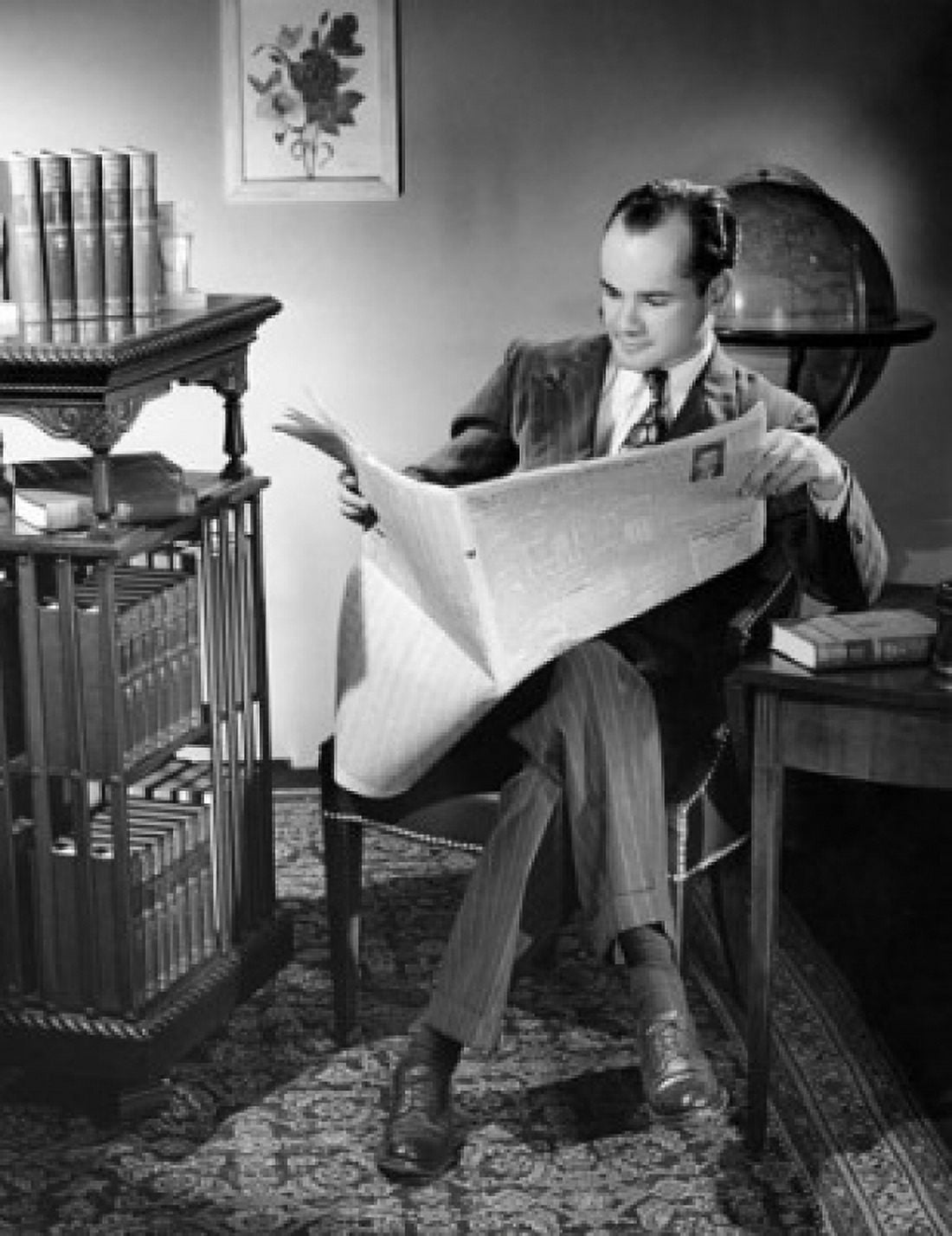 Mid adult man sitting in a chair and reading a newspaper Canvas Art - (18 x 24)