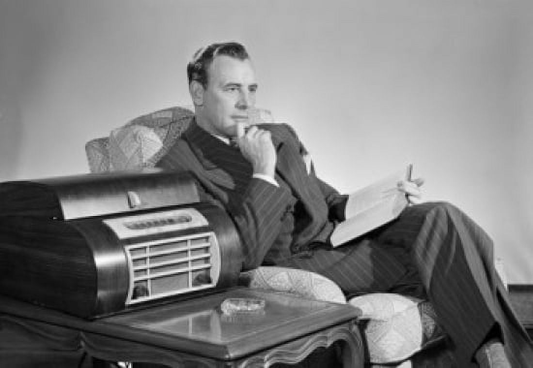Mid adult man sitting in an armchair and listening to music Canvas Art - (18 x 24)