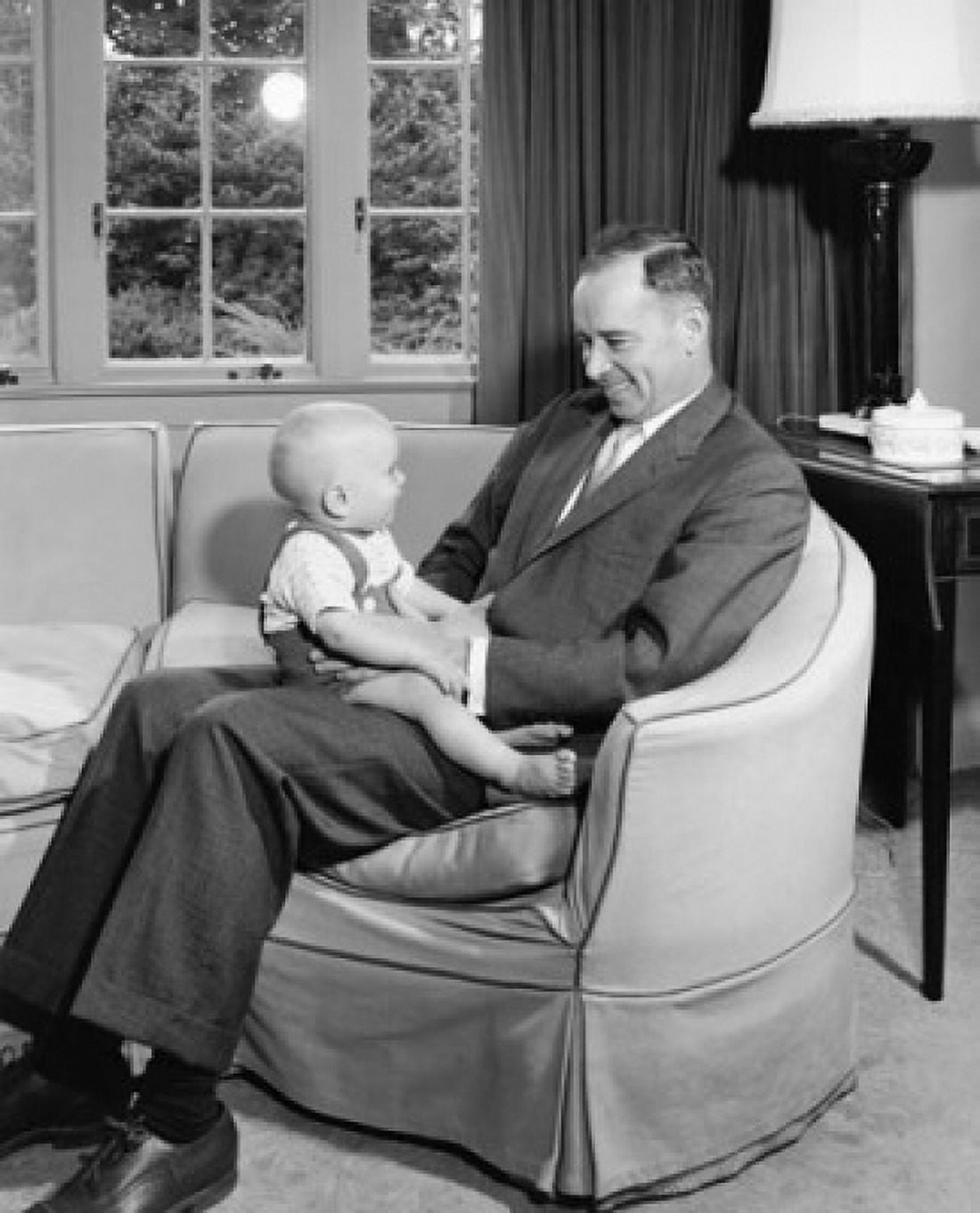 Mid adult man sitting in an armchair holding his son and smiling Canvas Art - (18 x 24)