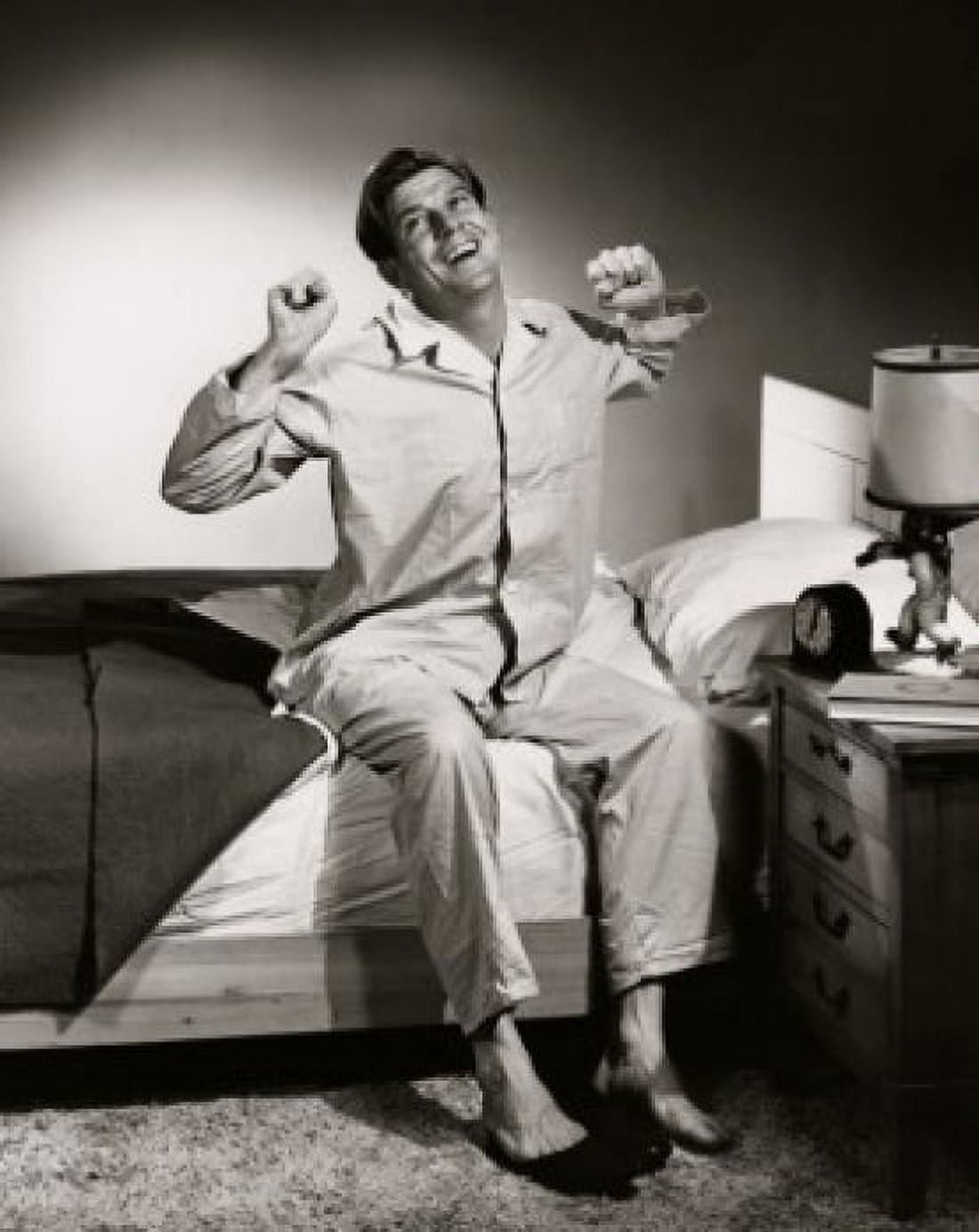 Mid adult man sitting on the edge of the bed stretching Canvas Art - (18 x 24)
