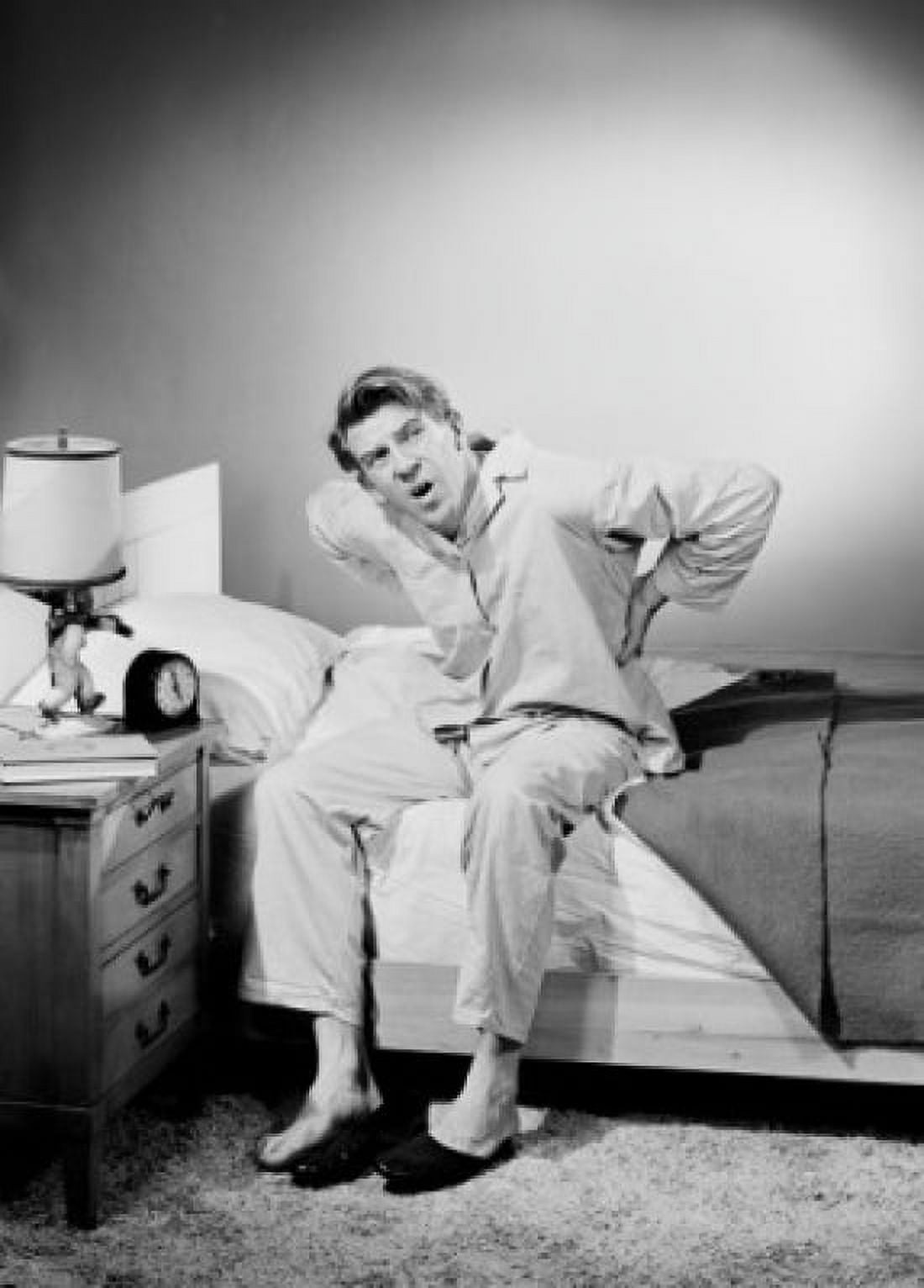 Mid adult man wearing pajamas sitting on bed Canvas Art - (24 x 36)
