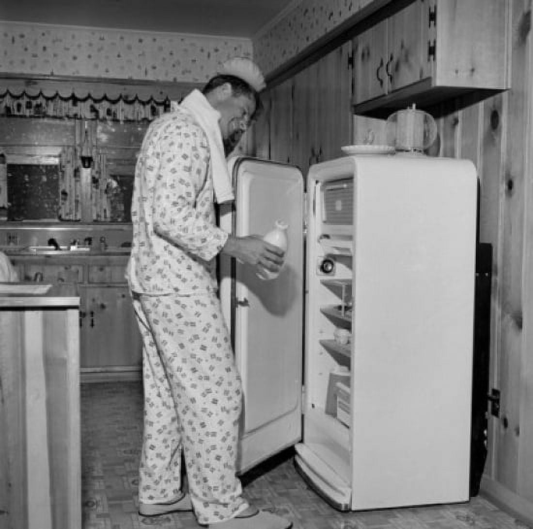 Mid adult man wearing pajamas taking milk from fridge Canvas Art - (24 x 36)