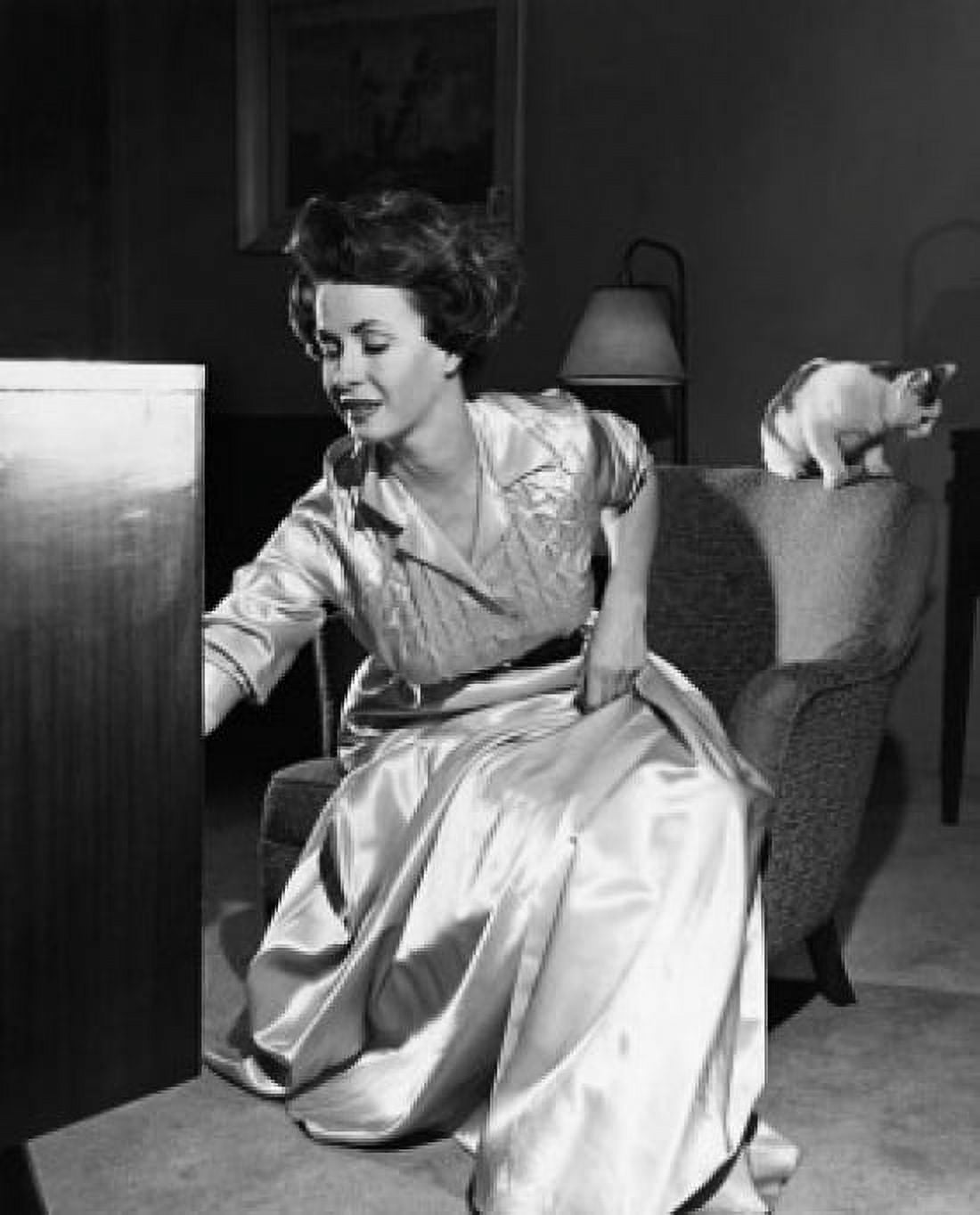 Mid adult woman adjusting a television Canvas Art - (18 x 24)