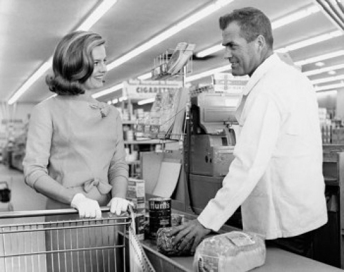Mid adult woman and a male sales clerk at the checkout counter in a super market Canvas Art - (18 x 24)