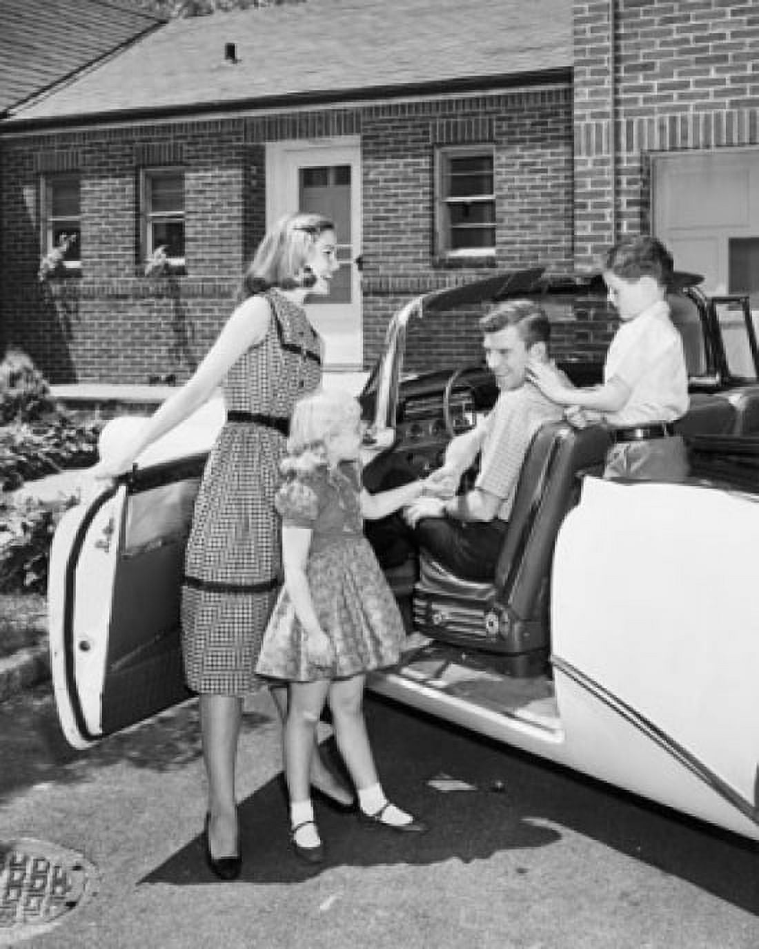 Mid adult woman and her daughter standing beside a car with a mid adult man and his son sitting in a car Canvas Art - (24 x 36)