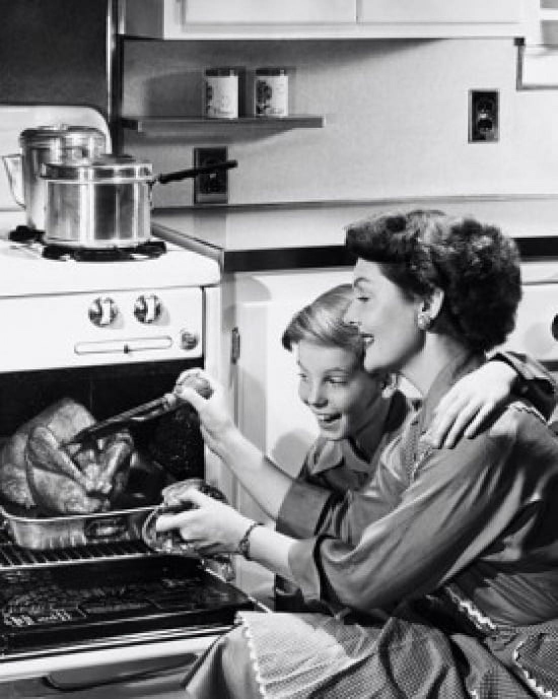 Mid adult woman basting turkey with son sitting beside her Canvas Art - (24 x 36)