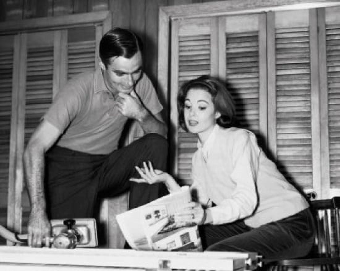 Mid adult woman holding a magazine and talking to a mid adult man Canvas Art - (18 x 24)