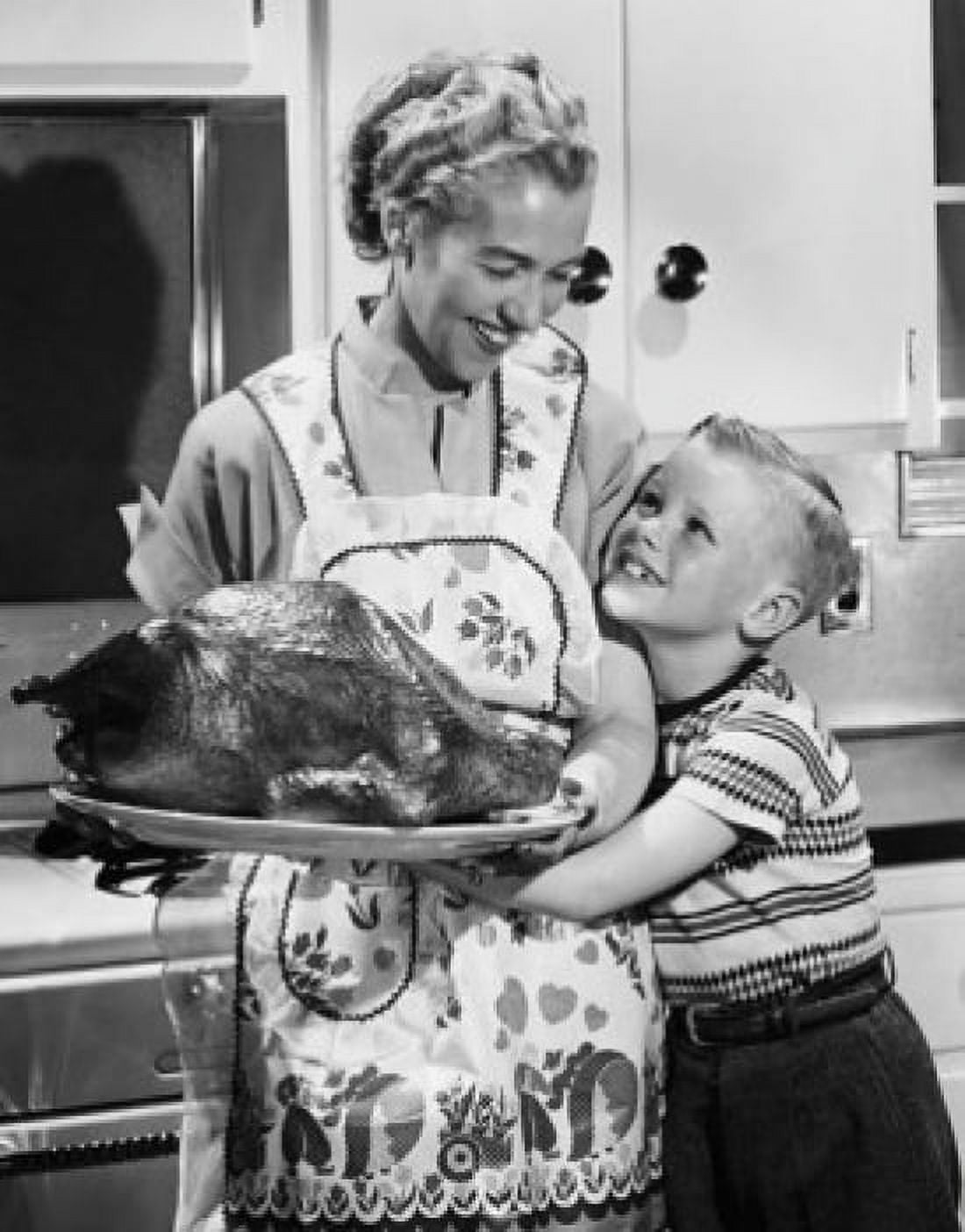 Mid adult woman holding a roast turkey with her son hugging her Canvas Art - (18 x 24)