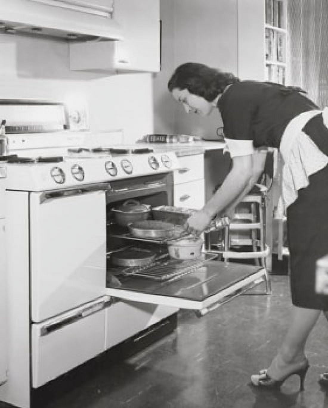 Mid adult woman putting food into an oven Canvas Art - (18 x 24)