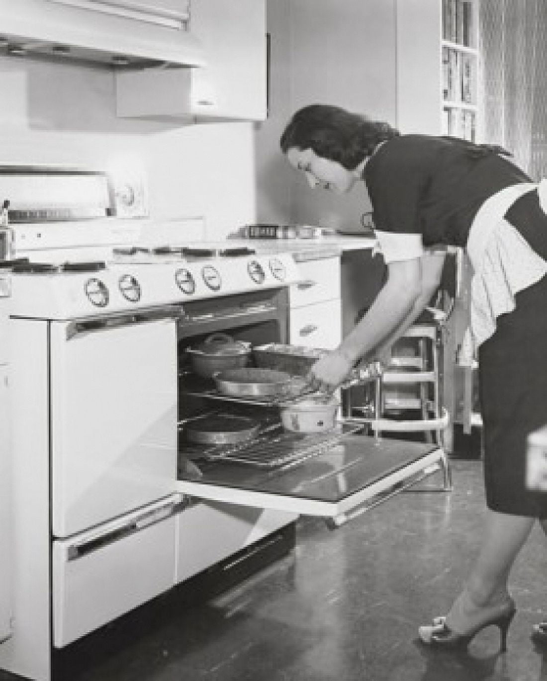 Mid adult woman putting food into an oven Canvas Art - (24 x 36)